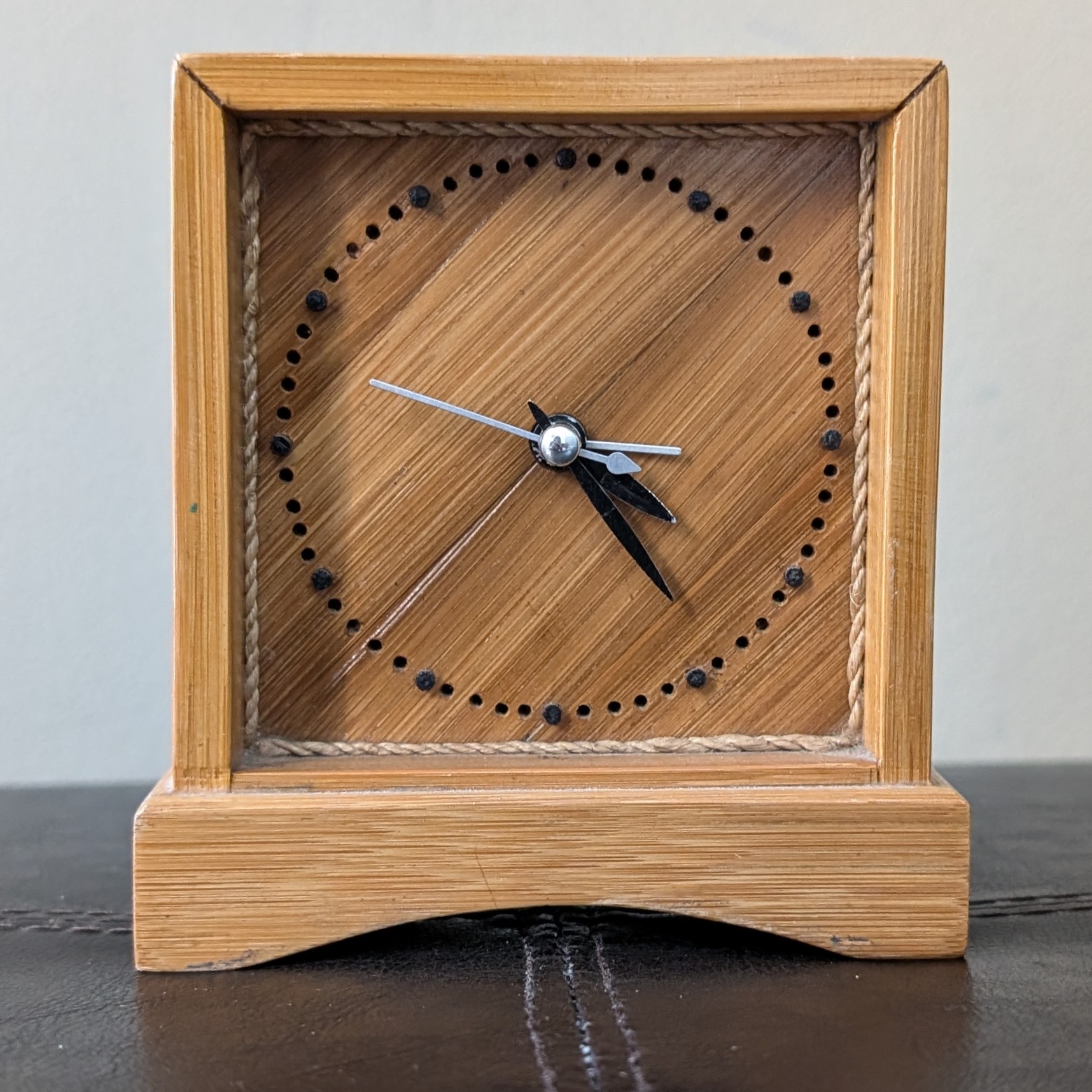 Wooden clock.<br>
                This is a gift my grandfather gave me. It's made out of bamboo. There is a border of
                string lining the inside of the clock.